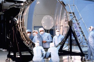 Astronomers examine the 2.4-meter mirror at the heart of the Hubble Space Telescope.