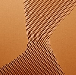 Where these two gold crystals meet they are joined by a complex arrangement of atoms, forming a nanobridge that accommodates their different orientations. The atoms are 2.3 angstroms apart. TEAM 0.5