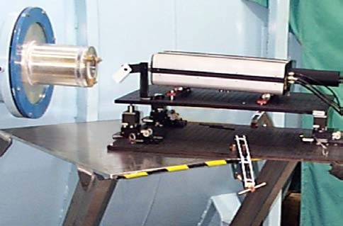 A dynamic interferometer measures a test sample in a vacuum chamber through a view port