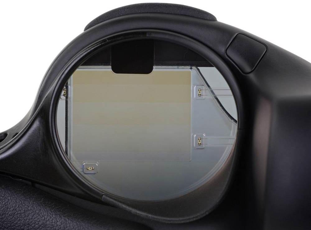 Close-up of the Magic Leap One smartglasses, which uses a stack of waveguide layers (visible as slight striations on the square element in the center left of the lens). There are 6 waveguide layers—two for each color channel (red, green, blue). The two electronic elements on the right side of the lens are NIR LEDs for sensing.
