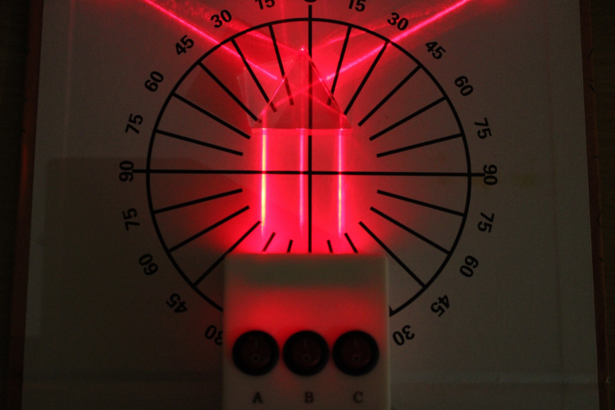 Optical box experiment showing behavior of laser beam light through a glass prism. Total internal reflection.
