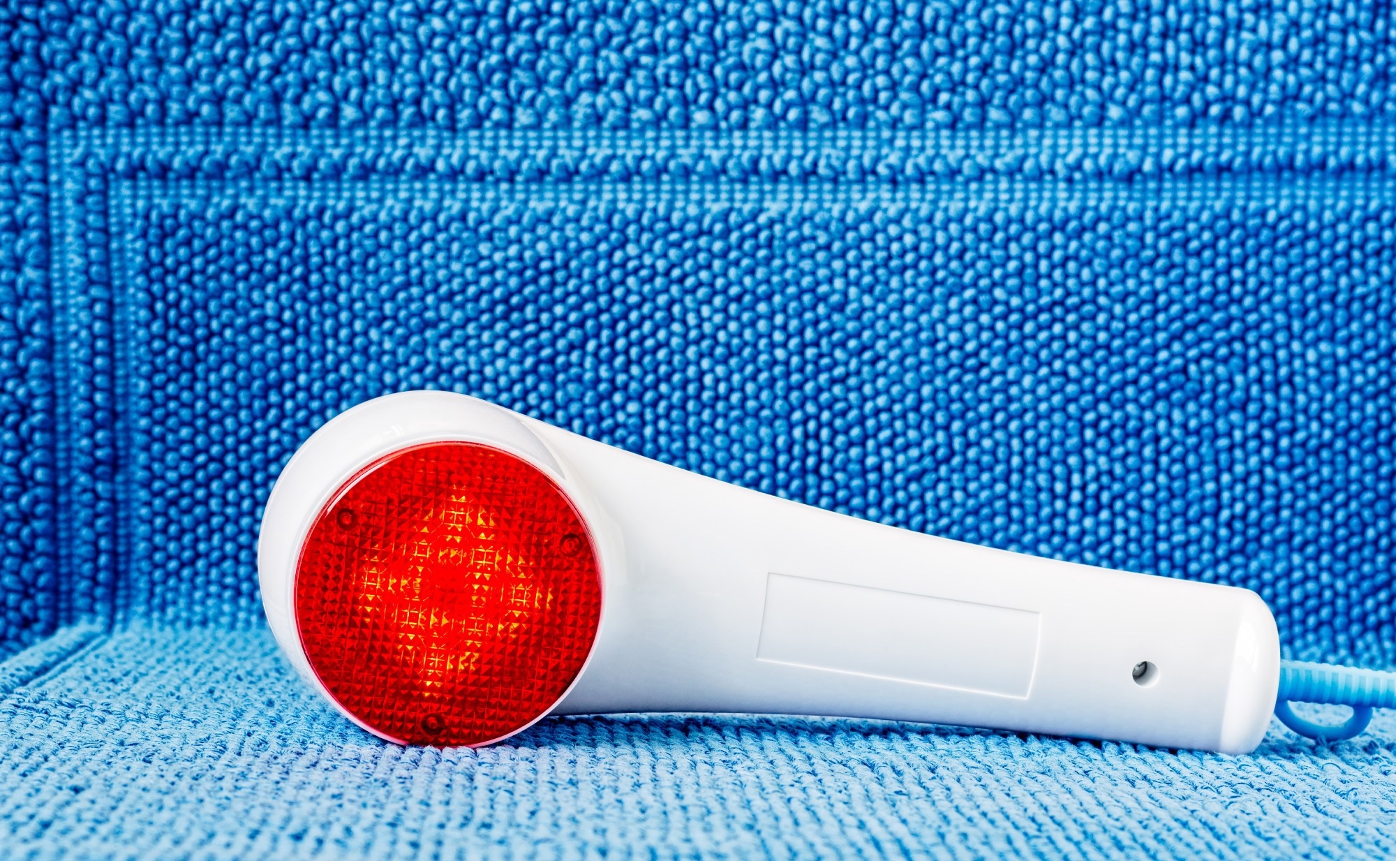 Photo of an infrared hand held massager turned on