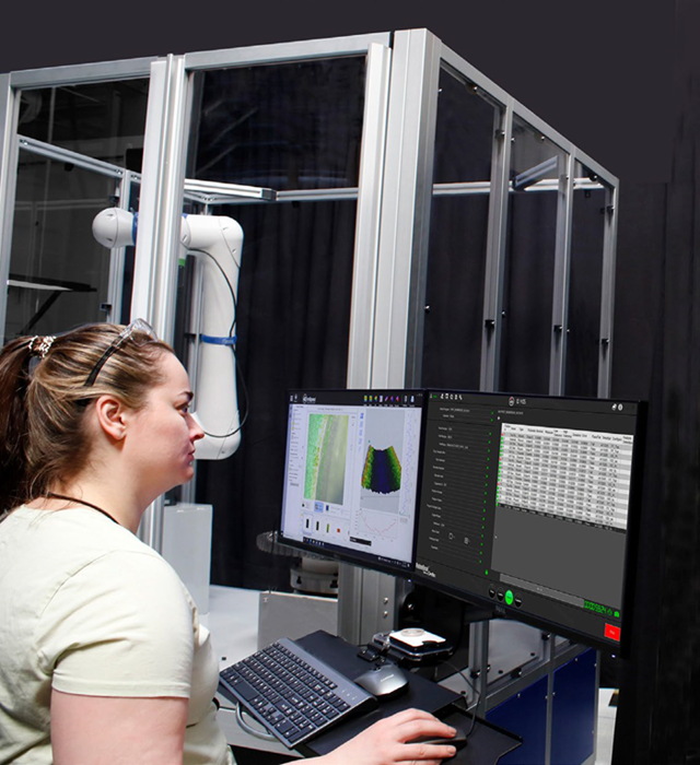 An inspector reviewing pass-fail results from a 4Di InSpec automated measurement system.