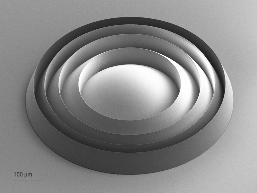 High quality Fresnel microlens printed with Two-Photon Grayscale Lithography 2GL<sup>®</sup>, an innovative technology based on multiphoton lithography. The lens shows a perfect central symmetric design with a very smooth convex lens shape, vertical walls and sharp angles