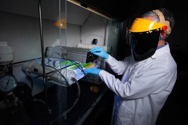Jacek Koziel adjusts infrared lamps and sensors in a Sukup Hall laboratory.