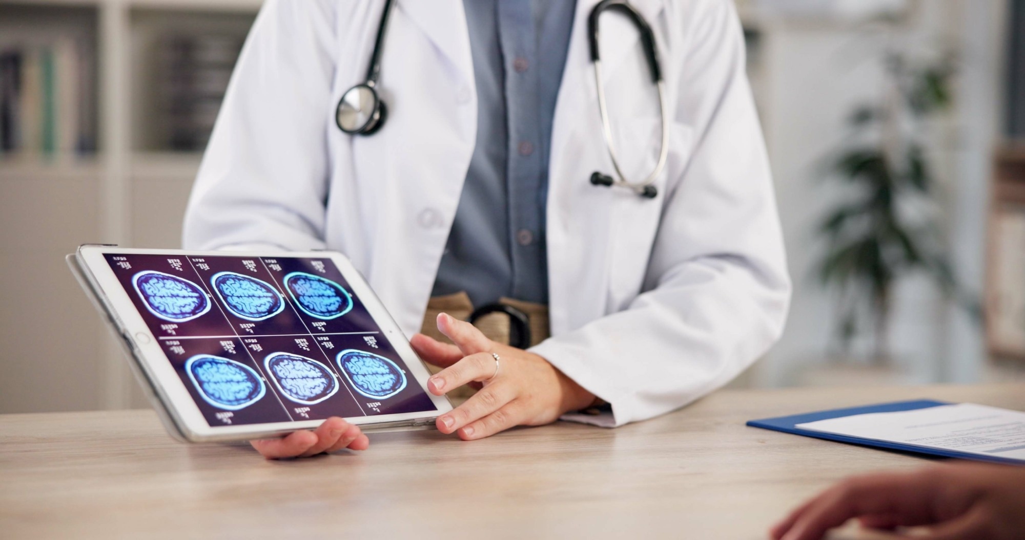 Doctor in a white coat showing six scans taken from an MRI